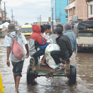 La charrette à bras comme seule option, pour ces personnes, hier, pour éviter de patauger dans les eaux pluviales de Besarety. (Photo Yvon RAM)